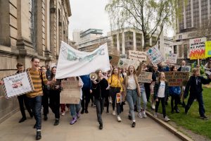 People march with climate change signs before the Global Climate Strike